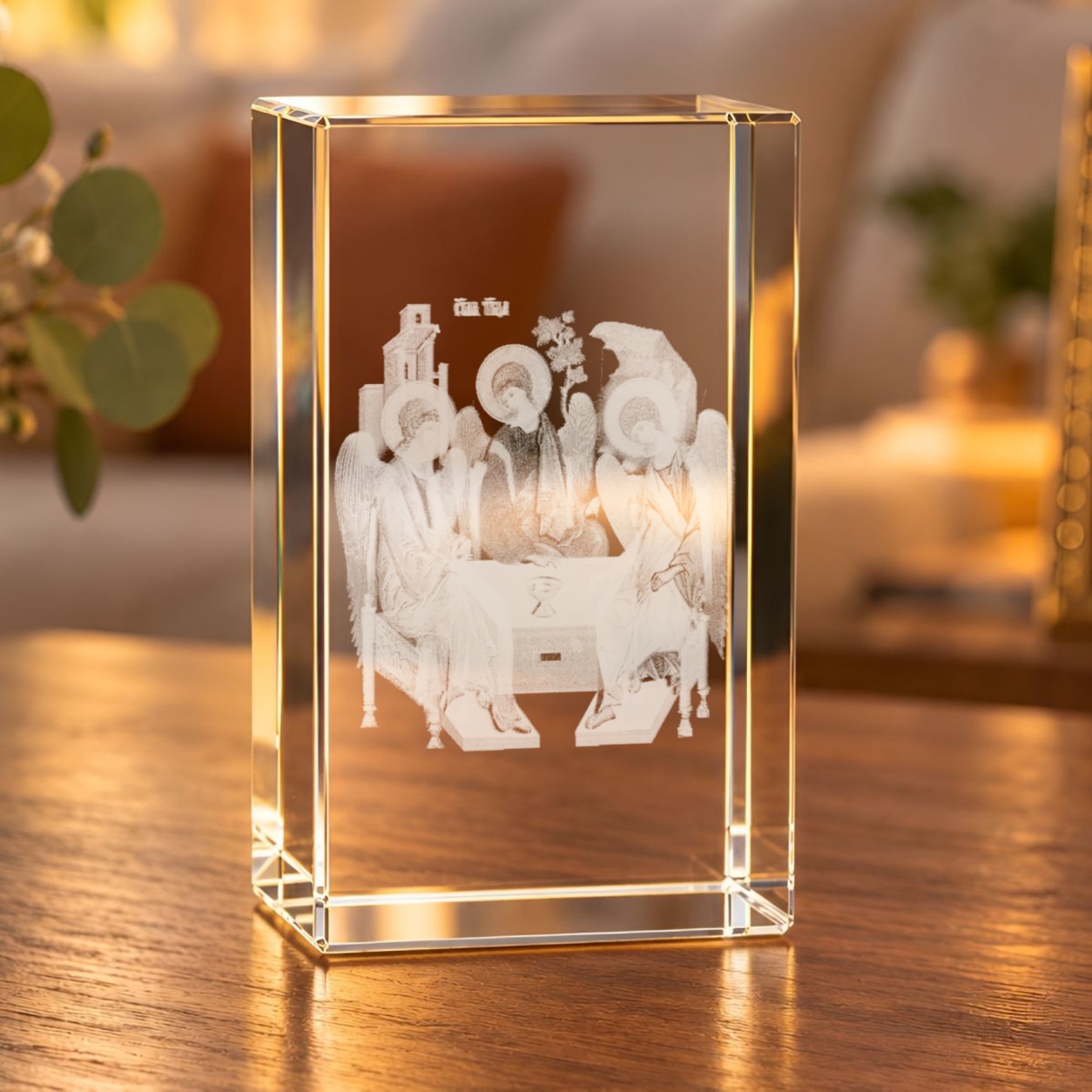 3D-Glaskristall Heilige Dreifaltigkeit mit Laserinnengravur auf einem Holztisch im warm beleuchteten Wohnzimmer