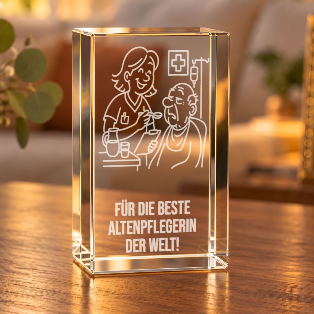 Glaskristall Altenpflegerin mit 3D-Laserinnengravur einer Pflegeszene und dem Schriftzug „Für die beste Altenpflegerin der Welt!“ auf einem Holztisch im Wohnzimmer