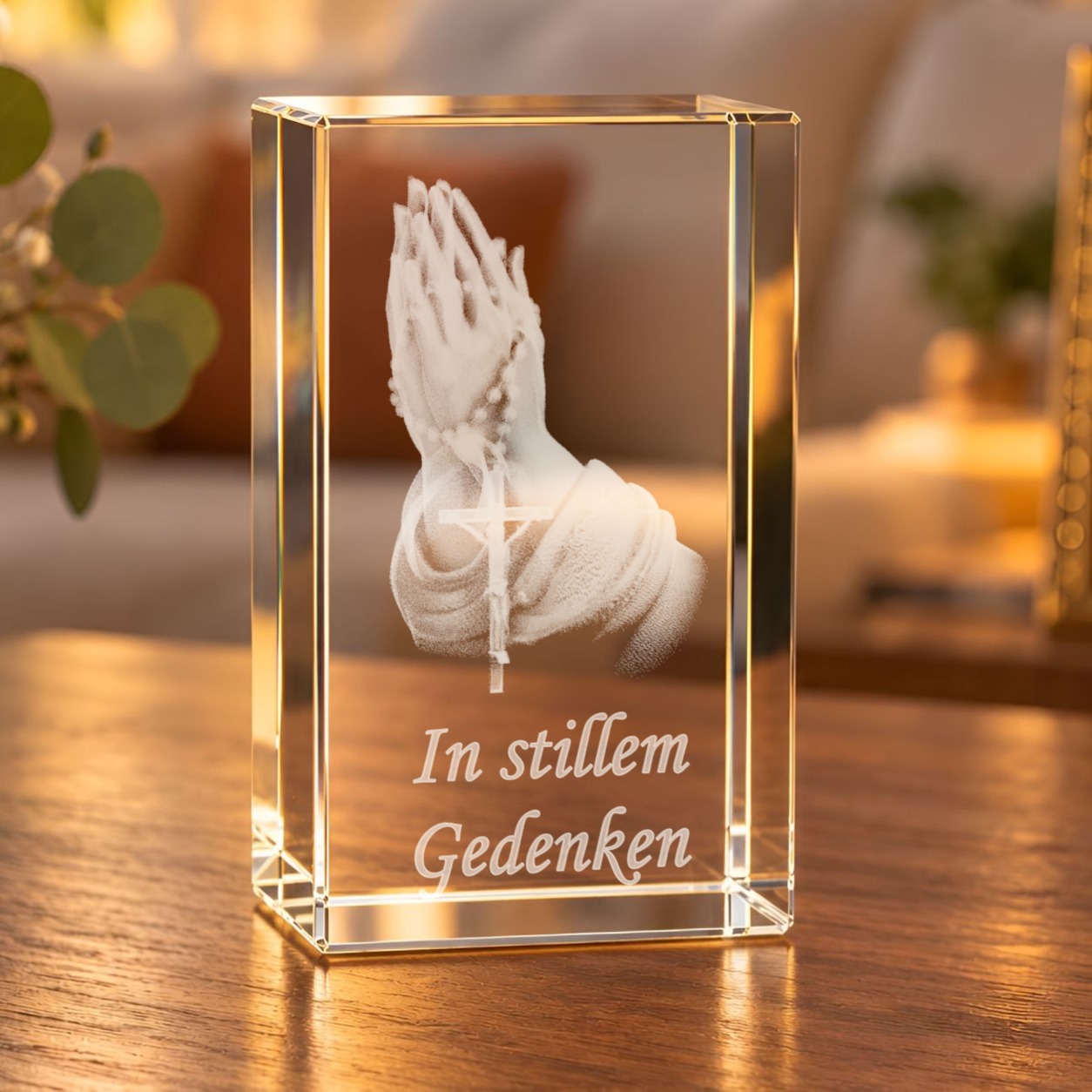 Glaskristall Betende Hände mit Rosenkranz und Schriftzug „In stillem Gedenken“ auf einem Holztisch im Wohnraum