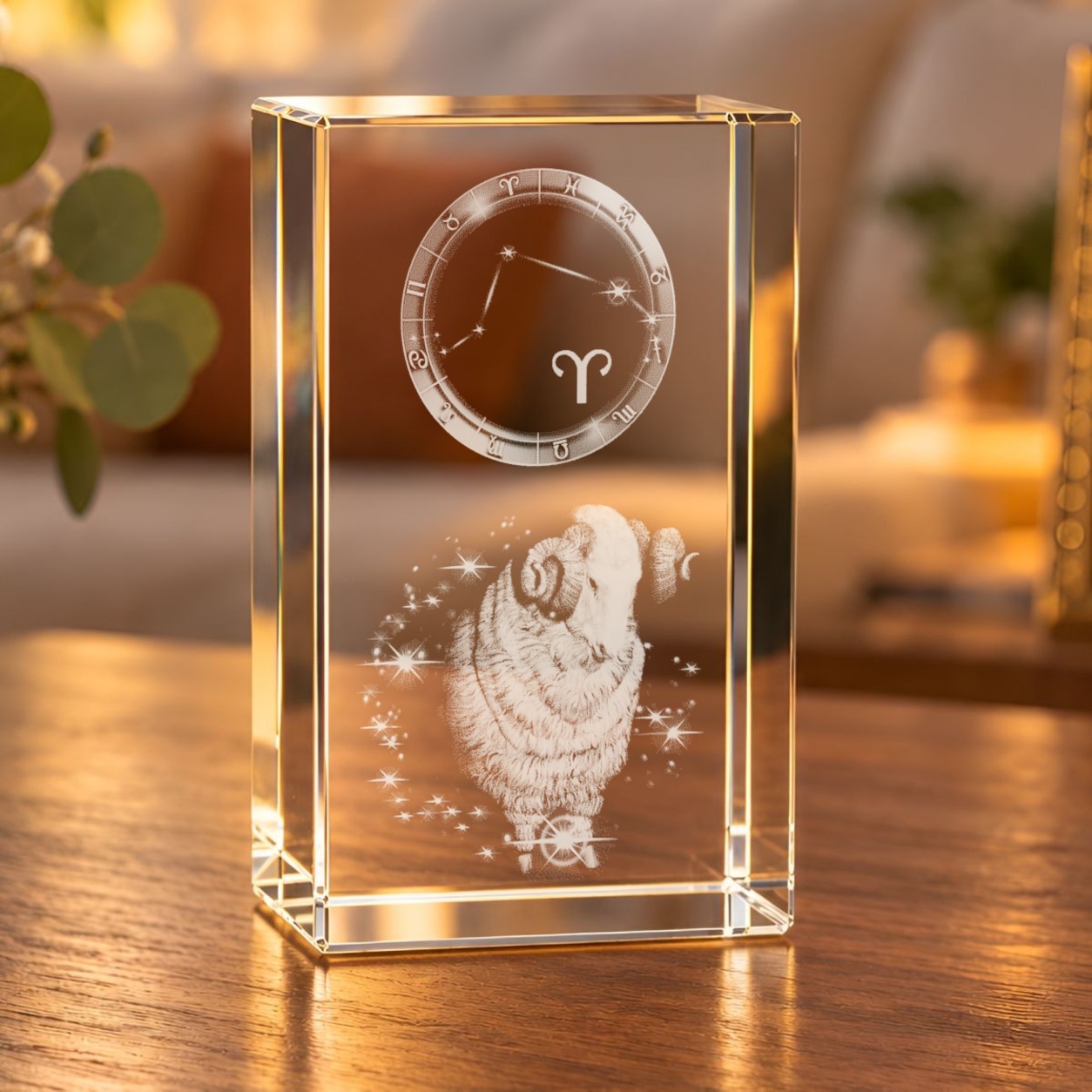 Glaskristall Sternzeichen Widder mit 3D-Innengravur aus Widder, Sternen und Tierkreisring auf einem Holztisch im Wohnraum