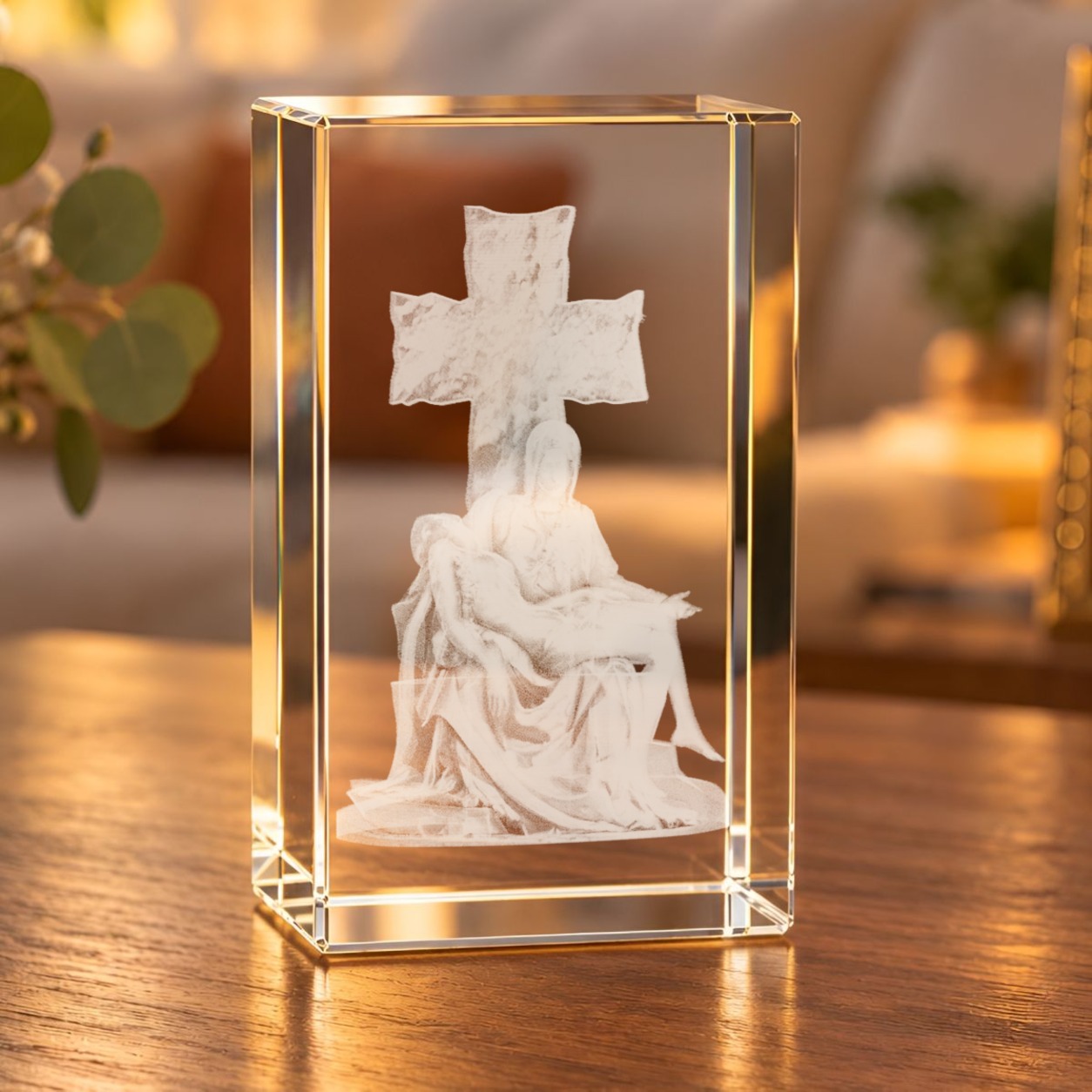 Glaskristall Pietà mit 3D-Laserinnengravur auf einem Holztisch im Wohnraum, Maria mit Jesus vor einem Kreuz