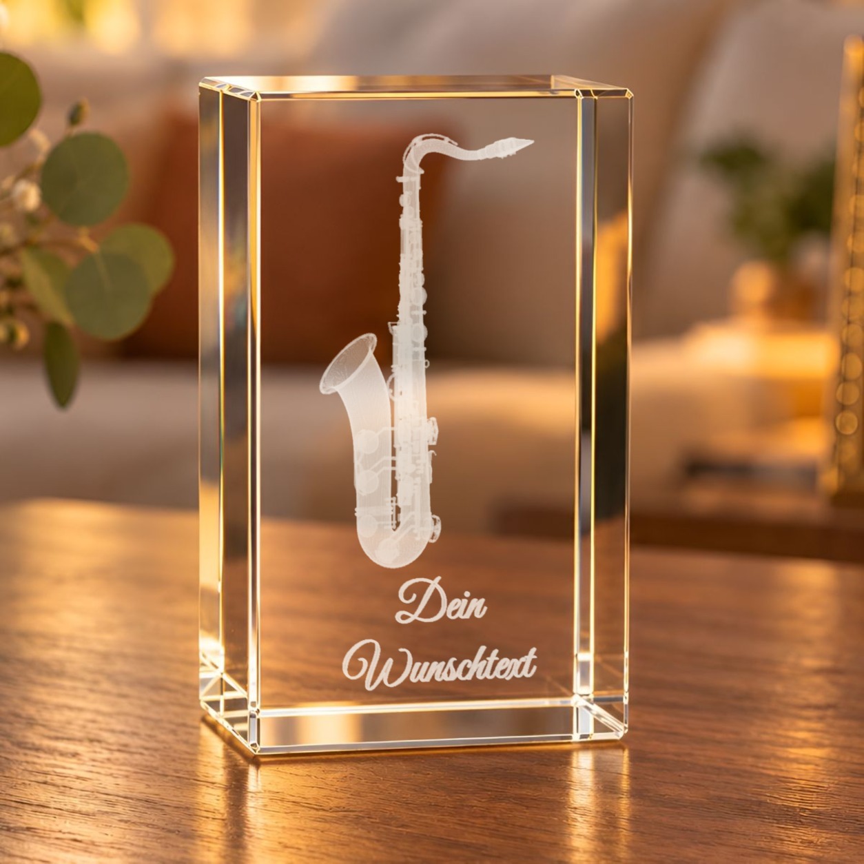 Glaskristall Saxofon mit Wunschtext: Saxofon als 3D-Laserinnengravur im Glasquader auf einem Holztisch im Wohnraum