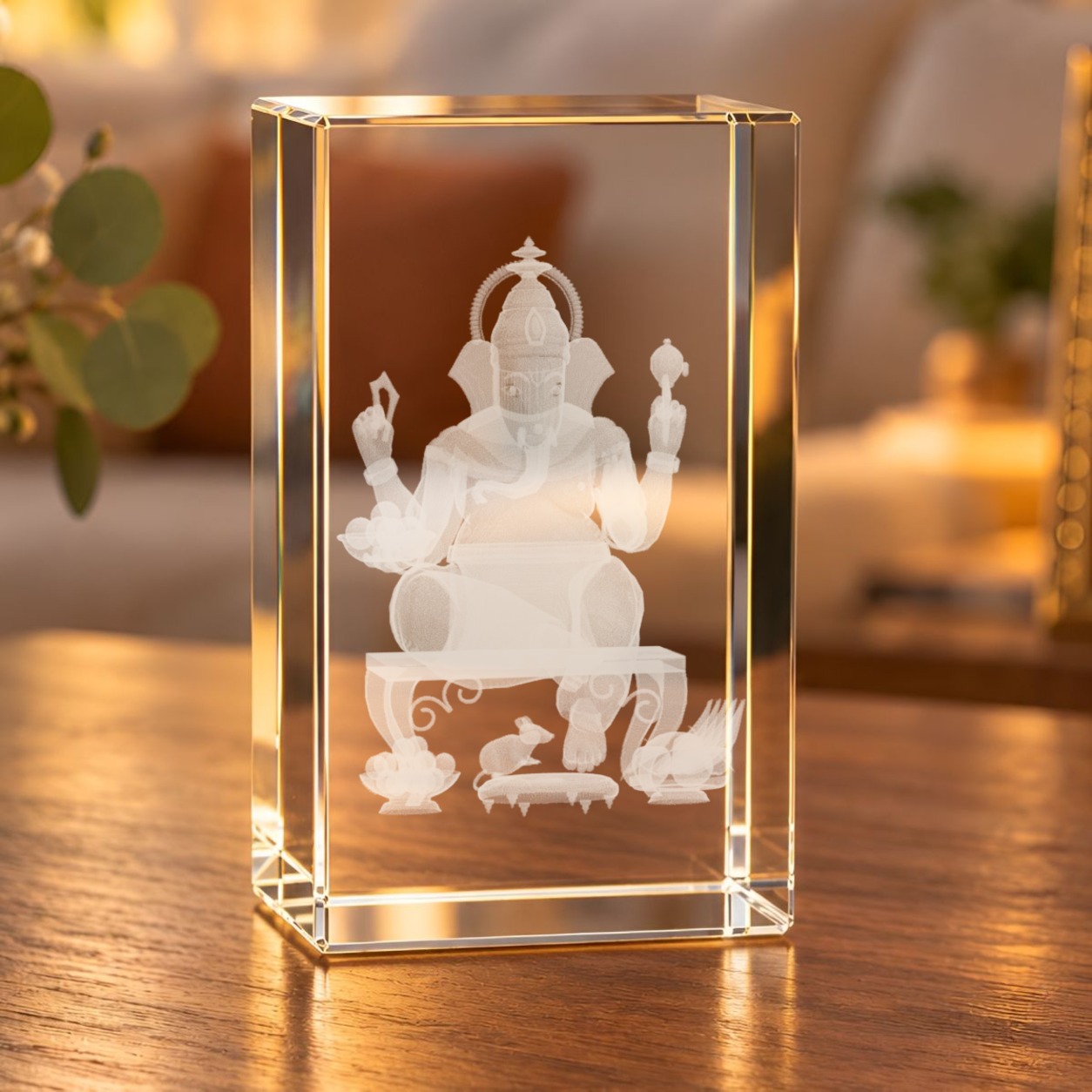 3D-Glaskristall Ganesha als Glasquader mit Laser-Innengravur auf einem Holztisch im warm beleuchteten Wohnzimmer