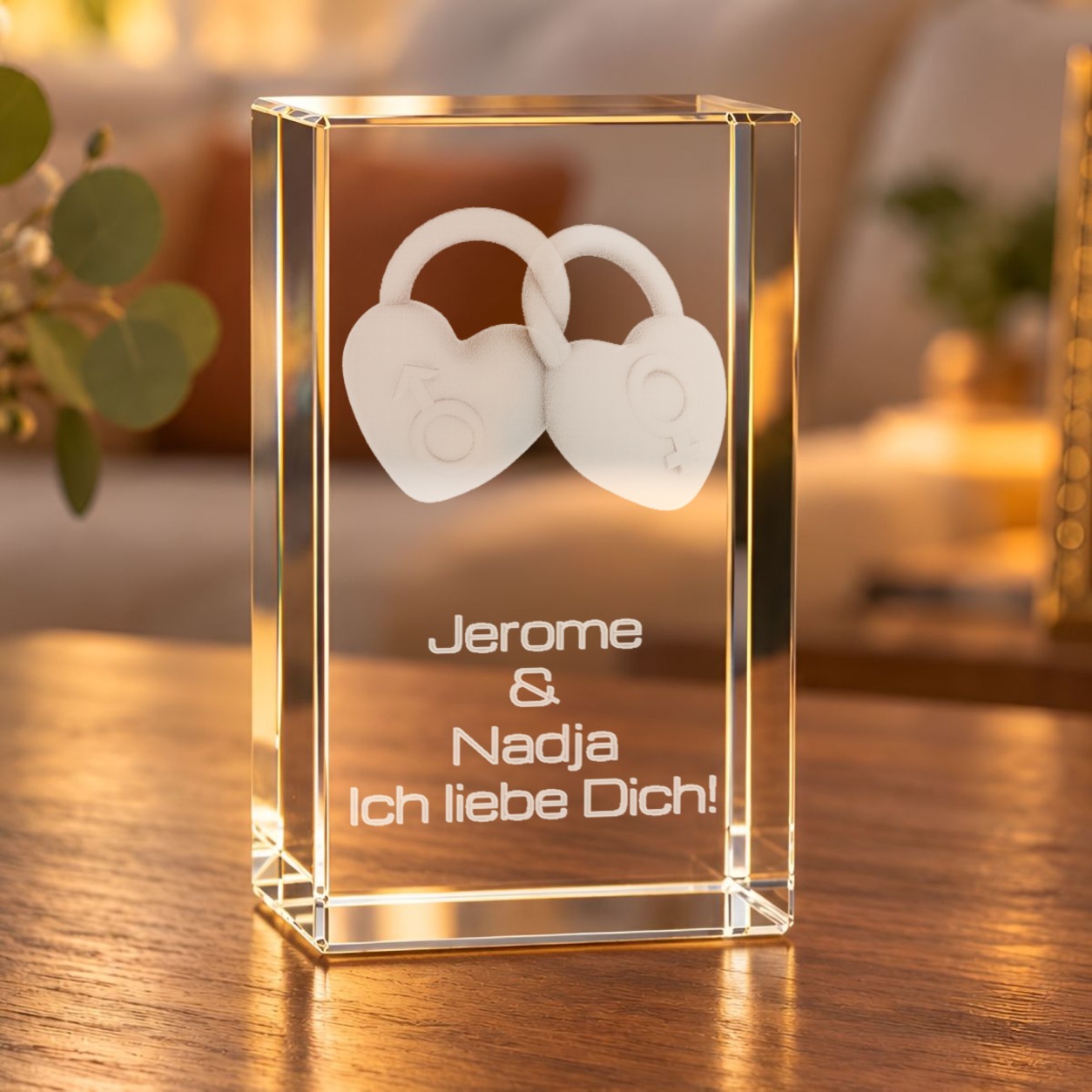 Glaskristall Liebesschlösser mit Wunschtext auf einem Holztisch im Wohnzimmer, zwei verbundene Herzschlösser als 3D-Gravur im Glas