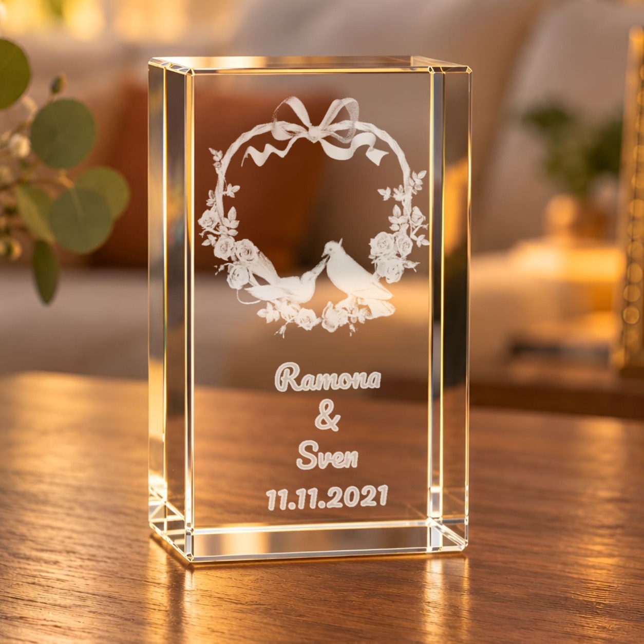 Glaskristall Herz mit Rosen und Tauben mit Wunschtext, beleuchtet auf einem Holztisch im Wohnzimmer