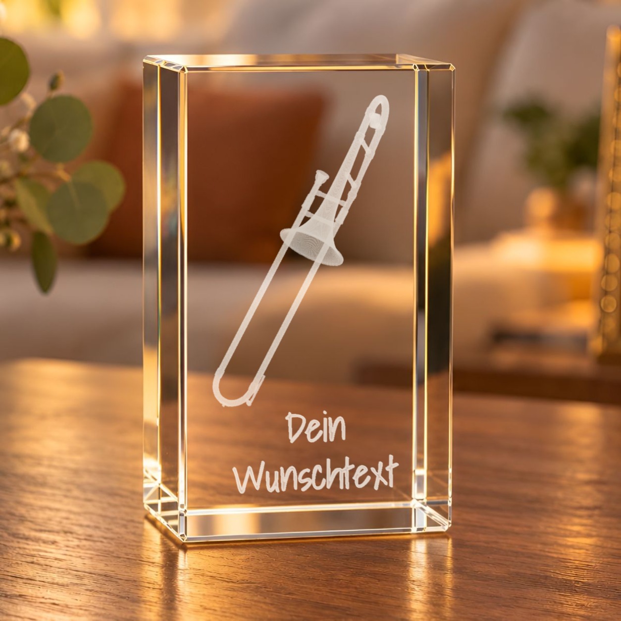 Glaskristall Posaune mit Wunschtext, 3D-Lasergravur einer Zugposaune, auf einem Holztisch im Wohnzimmer