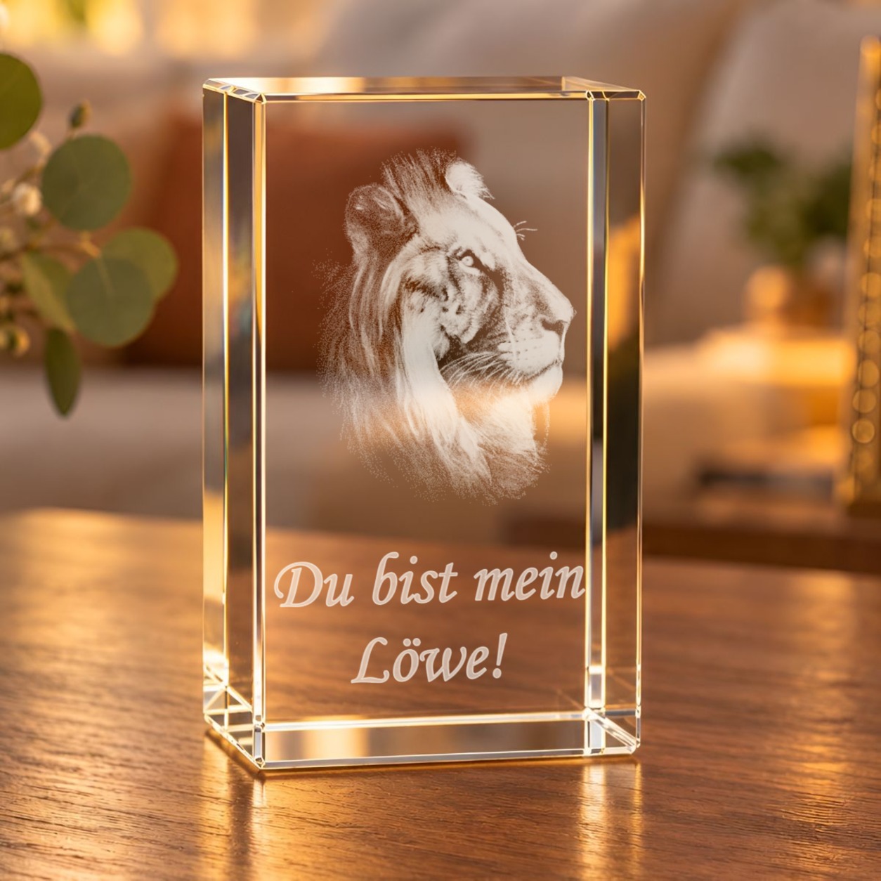 3D-Glaskristall Löwenkopf mit Laserinnengravur auf einem Holztisch im Wohnzimmer, warm beleuchtet