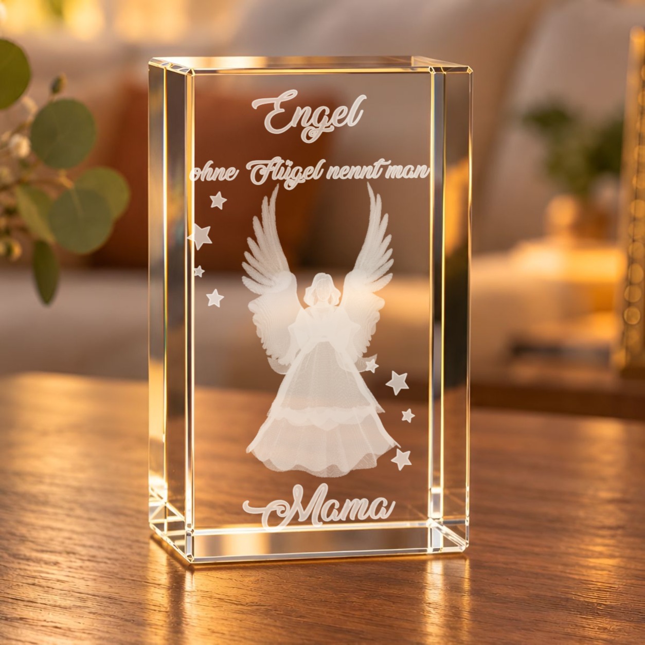 3D-Glaskristall Engel mit dem Spruch „Engel ohne Flügel nennt man Mama“ auf einem Holztisch im Wohnzimmer