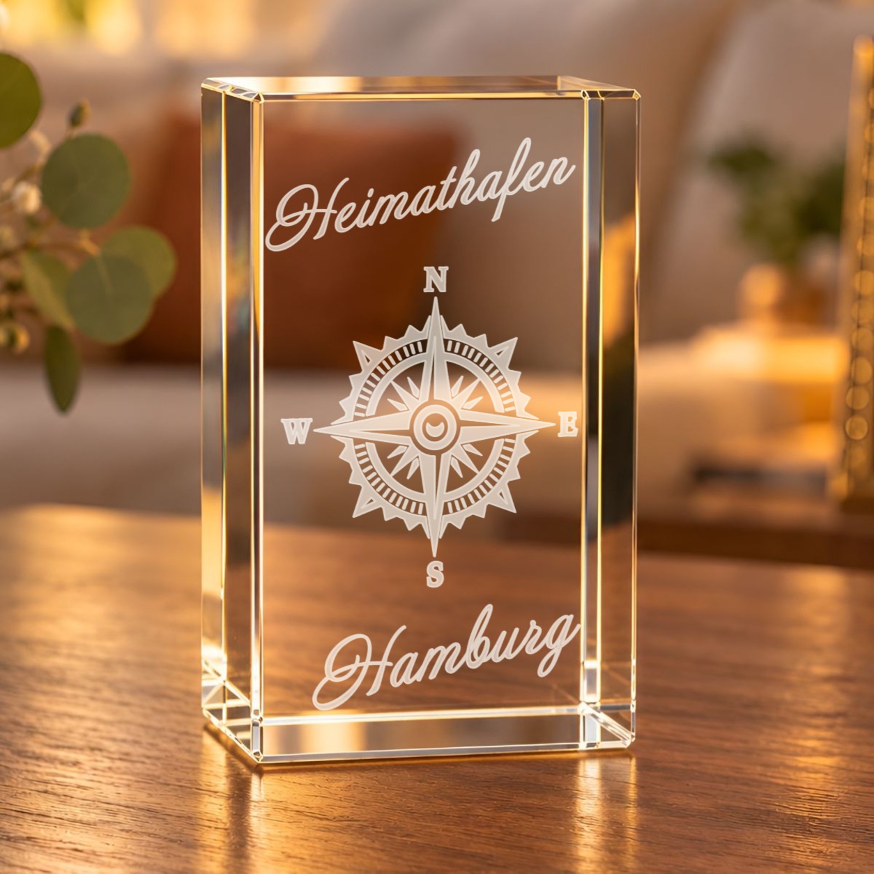 Glaskristall Windrose Hamburg mit Schriftzug Heimathafen als 3D-Laserinnengravur, auf einem Holztisch im Wohnraum