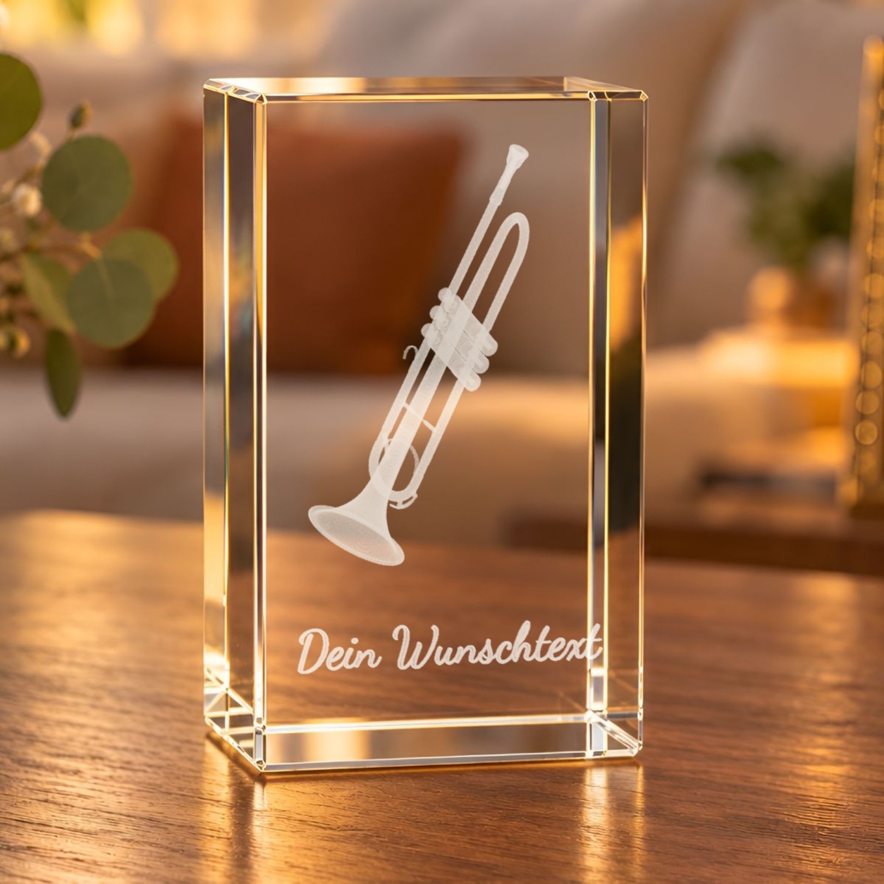 3D-Glaskristall Trompete mit Wunschtext auf einem Holztisch im Wohnzimmer, warm beleuchtet